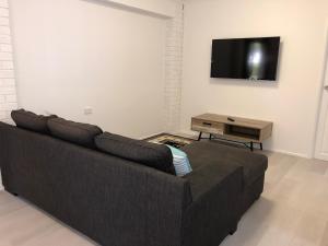 a living room with a couch and a flat screen tv at Airlie Getaway Unit 3 in Cannonvale