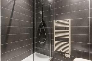 La salle de bains est pourvue d'une douche et de toilettes. dans l'établissement HOME SWEET VAISE, à Lyon