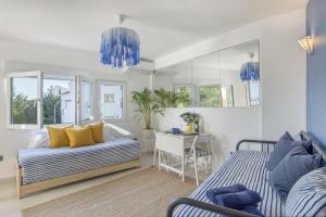 een slaapkamer met 2 bedden, een bureau en blauwe kroonluchters bij Shiny Studio with Pool & Carihuela Beach at 500m in Torremolinos