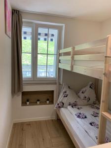 a bedroom with two bunk beds and a window at Eiger, Jungfrau, luxury garden apartment in Grindelwald