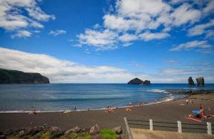 a group of people on a beach near the water at Cantinho do Sol in Mosteiros