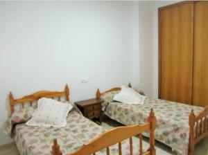 a bedroom with two beds and a dresser in it at Apartamento Playa de Garrucha in Garrucha +1 photo