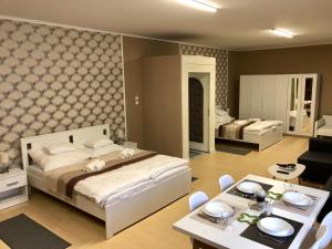ein Schlafzimmer mit einem Bett und ein Wohnzimmer in der Unterkunft Árkád Apartmanház Szeged in Szeged