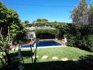 una piscina en un patio con pérgola en Villa Paradise Private pool and garden in a natural park for 9 en Aduanas