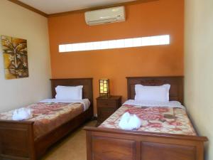 ein Schlafzimmer mit zwei Betten mit weißen Katzen darauf in der Unterkunft Manichan Guesthouse in Luang Prabang