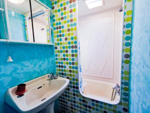 Baño azul con lavabo y espejo en Au Bonheur Nomade, en Livry