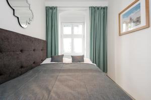 a bedroom with a bed with green curtains and a window at 4 Personen Altbau nahe Kurfürstendamm - Macbeth in Berlin