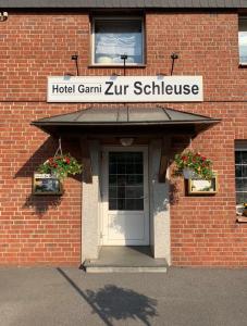 un edificio con una puerta y un cartel que lee hotel campamento de neurociencia en Hotel Zur Schleuse (Garni), en Datteln