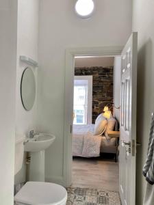 uma casa de banho com um lavatório e uma cama num quarto em Room 2 Camp Street B&B & Self Catering em Oughterard