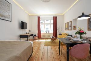 4 Personen Altbau Apartment nahe Kurfürstendamm - Romeo & Julia في برلين: غرفة معيشة مع سرير وغرفة طعام