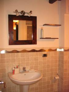 ein Bad mit einem Waschbecken und einem Spiegel in der Unterkunft Lovely Stone House Conversano Puglia in Conversano