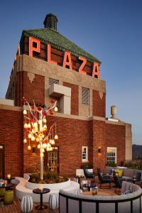 a brick building with a sign that reads pizza at The Plaza Hotel Pioneer Park in El Paso