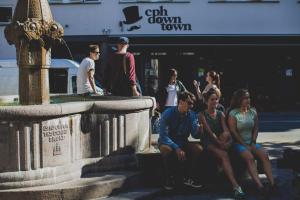 eine Gruppe von Menschen, die neben einem Brunnen sitzen in der Unterkunft Copenhagen Downtown Hostel in Kopenhagen