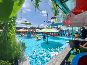 a large swimming pool with people in it at Khách sạn Vườn Cau & Khu vui chơi giải trí SaLa in Tây Ninh