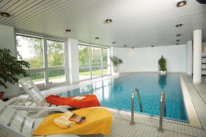 a large swimming pool with two chairs and a tub at Gästehaus Wilgersdorf GmbH in Wilnsdorf