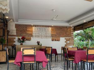 a restaurant with tables and chairs and a brick wall at Làng biển Homestay in Quảng Ngãi