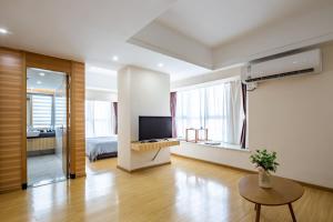 sala de estar amplia con TV y cama en Guardian Residence, en Changsha