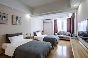Habitación de hotel con 2 camas y sofá en Guardian Residence, en Changsha