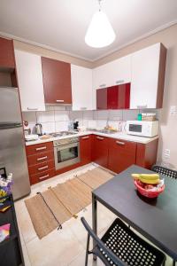 a kitchen with red and white cabinets and a table at Anthia Seaview Apartment in Kalamata