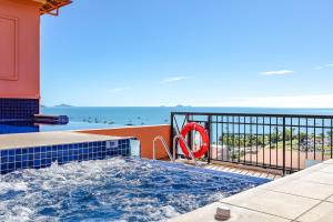 a swimming pool with the ocean in the background at Martinique Whitsunday Resort in Airlie Beach
