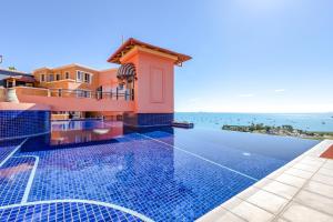 a villa with a swimming pool with a view of the ocean at Martinique Whitsunday Resort in Airlie Beach