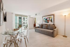 een woonkamer met een bank en een glazen tafel bij Miami Downtown Brickell Popular 4 BedRooms Bayview in Miami