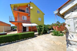 a yellow and orange building with a plant at Apartments Blaza in Božava