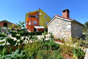 a house and a building with a yard with plants at Apartments Blaza in Božava