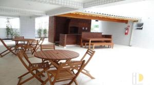 a patio with tables and chairs and a fireplace at AP Padrão Pé na Areia Centro TOP TODO COM AR CONDICIONADO in Mongaguá
