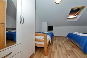 a small room with two beds and a chair at Apartments Blaza in Božava