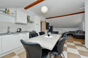 a kitchen and dining room with a table and chairs at Apartments Blaza in Božava