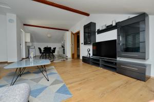 a living room with a large television and a table at Apartments Blaza in Božava