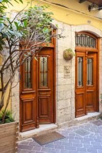 a pair of wooden doors on the side of a house at Charming Flatlet in the Old Town in Chania