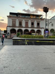 a building on a street with a person walking past it at Casa Hidalgo in Ciudad Hidalgo