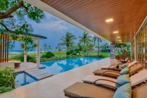 an outdoor pool with lounge chairs and a swimming pool at The Five Stars Villa 6 Bedrooms Beachfront in Danang
