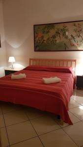a bedroom with a red bed with two pillows on it at Apartamento Vittoria Marina di Pietrasanta in Pietrasanta