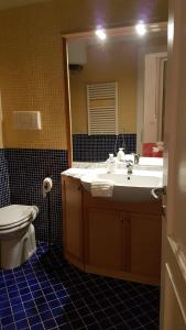 a bathroom with a sink and a toilet and a mirror at Apartamento Vittoria Marina di Pietrasanta in Pietrasanta