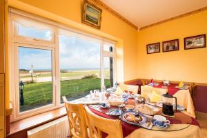 a dining room with a table and a large window at Bertra House B&B in Westport
