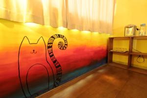 una camera con una parete colorata e un gatto dipinto sopra di Seville Countrified B&B a Città di Hualien