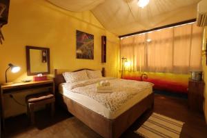 a bedroom with a bed and a table and a mirror at Seville Countrified B&B in Hualien City