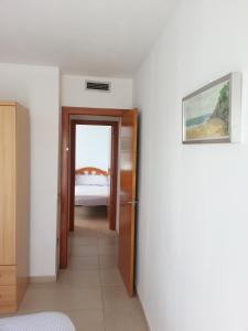 a hallway leading to a bedroom with a bed at Costa Dorada Miami in Miami Platja