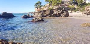 a beach with some rocks and the water at Costa Dorada Miami in Miami Platja