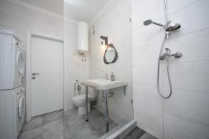 ein Bad mit einer Dusche, einem Waschbecken und einem WC in der Unterkunft Slavutich apartment #4 in Kiew