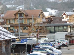 维尔德斯韦尔Gasthof Hirschen in Wilderswil的建筑物前停放汽车的停车场