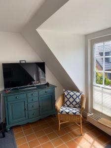 ein Wohnzimmer mit einem blauen Schrank und einem TV in der Unterkunft Kastanienhüs Apartment in Westerland