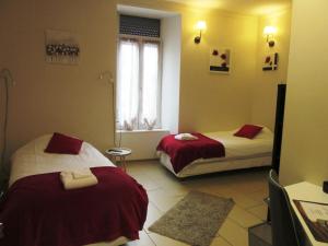 um quarto de hotel com duas camas e uma janela em Logis Hôtel des Causses em Millau