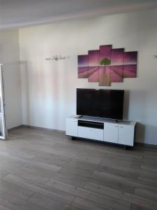 a living room with a tv and a white cabinet at Apartments Mara Seget Vranjica in Seget Vranjica