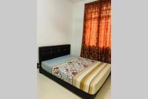 uma cama num quarto com uma cortina em Laman Aidids @ Krubong Melaka em Kampong Lanjut Manis