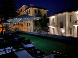 a patio with chairs and umbrellas at night at Millstone House in La Spezia