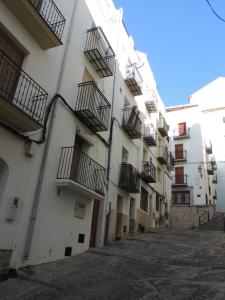 eine Gasse mit Balkonen an der Seite eines Gebäudes in der Unterkunft APARTAMENTO NURIA GONZÁLEZ GRANDA in Peñíscola